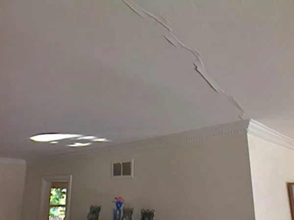 Деформация обрешетки на потолке привела к появлению трещины.