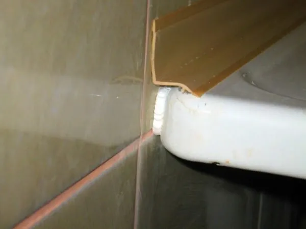 Пластиковый плинтус наклеен вдоль края ванны. Шов под ним дополнительно заделан герметиком.